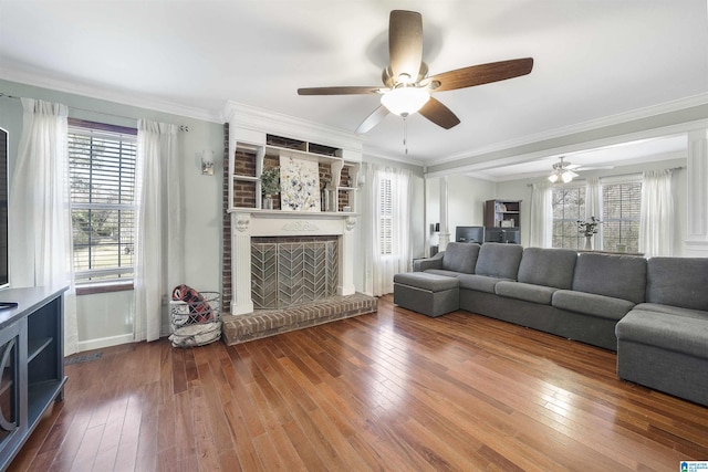 living area with hardwood / wood-style floors, a brick fireplace, and ceiling fan