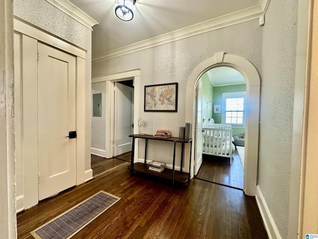 corridor featuring visible vents, arched walkways, crown molding, and a textured wall