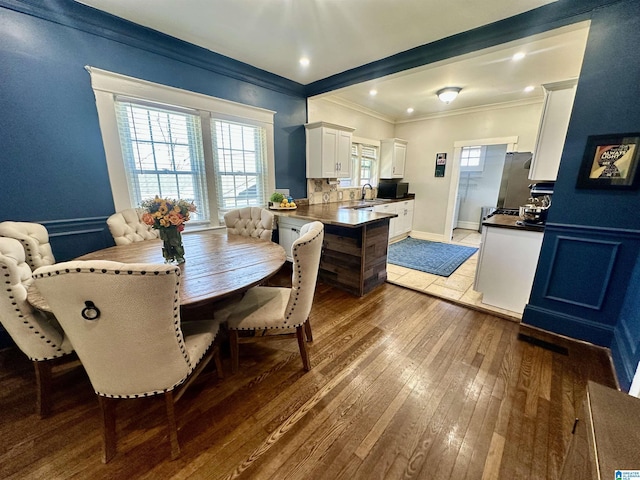 dining space with recessed lighting, crown molding, and hardwood / wood-style flooring