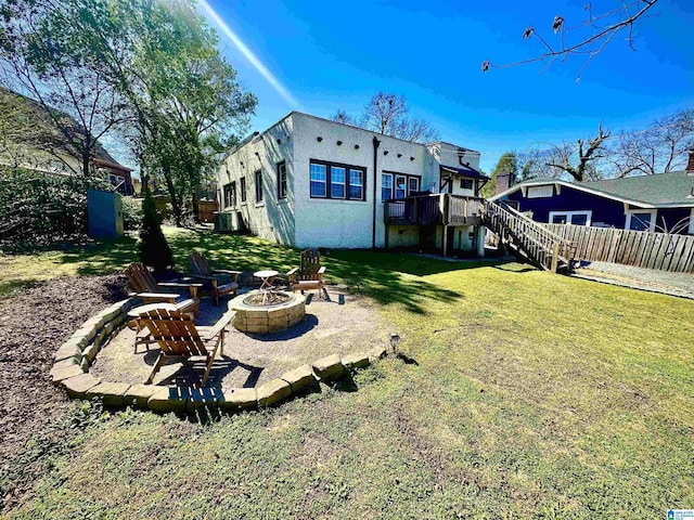 view of yard with fence, a wooden deck, an outdoor fire pit, stairs, and central AC