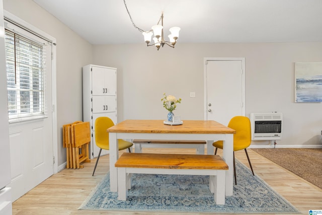 dining room with baseboards, heating unit, light wood-style floors, and an inviting chandelier