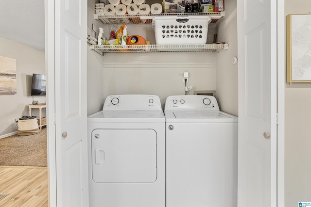 laundry area featuring laundry area, wood finished floors, baseboards, and separate washer and dryer