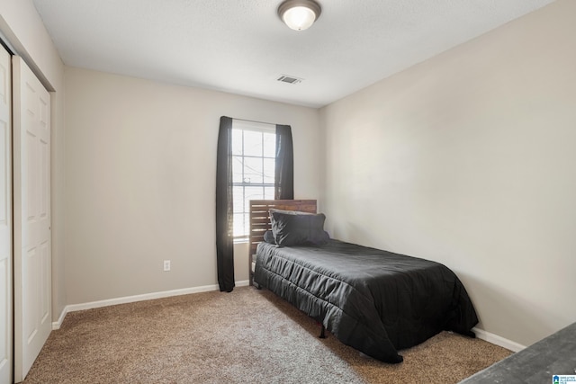 carpeted bedroom with visible vents and baseboards