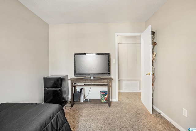 carpeted bedroom featuring visible vents, a textured ceiling, and baseboards