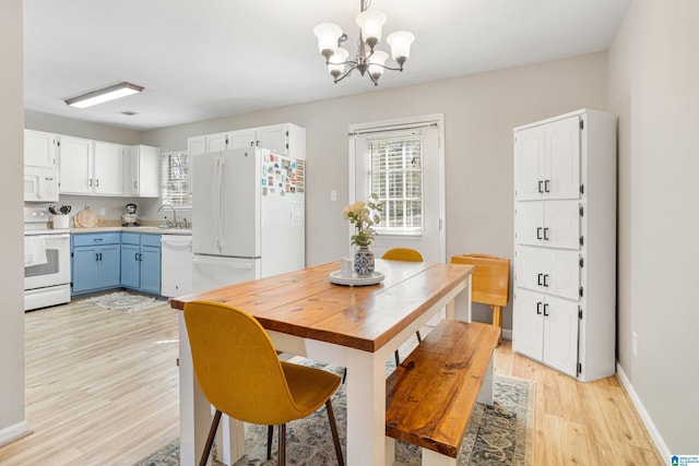 dining room featuring baseboards, light wood finished floors, and a chandelier