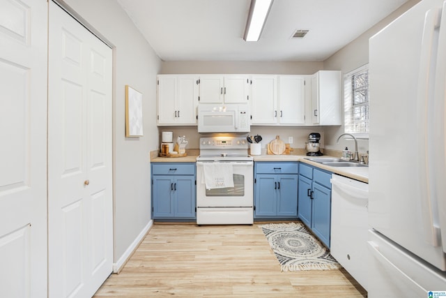 kitchen with visible vents, white cabinets, white appliances, blue cabinets, and a sink