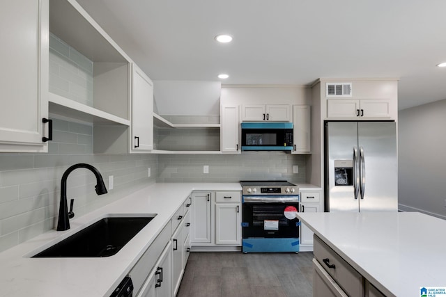 kitchen with visible vents, open shelves, a sink, white cabinets, and appliances with stainless steel finishes