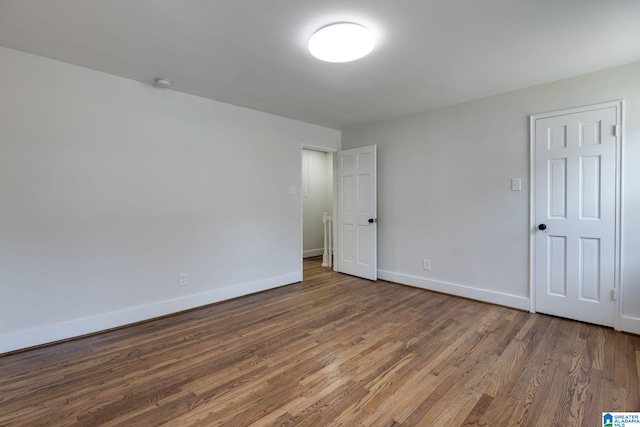 spare room with wood finished floors and baseboards