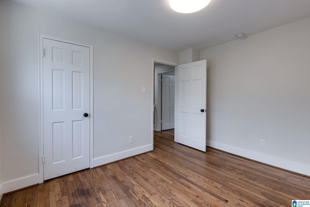 unfurnished bedroom with baseboards and wood finished floors