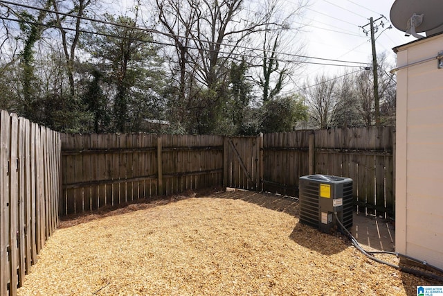 view of yard with central AC and a fenced backyard