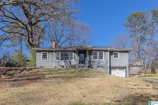 ranch-style house featuring an attached garage, a chimney, and a front yard