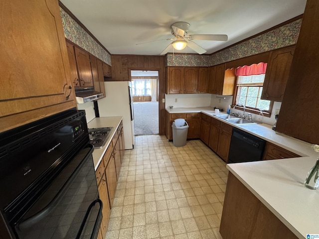 kitchen with a wealth of natural light, light floors, black appliances, and exhaust hood