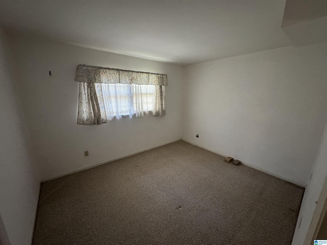 carpeted empty room featuring baseboards