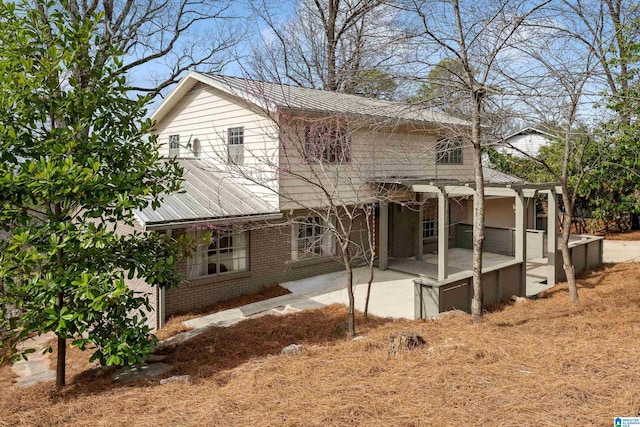 view of front of property with brick siding and a patio area