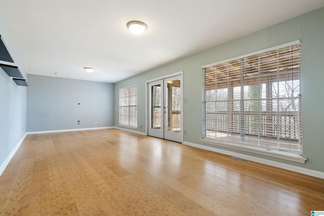 empty room with visible vents, baseboards, and wood finished floors