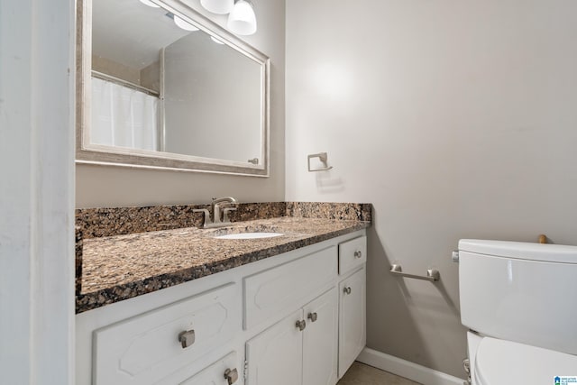 full bathroom with baseboards, toilet, and vanity