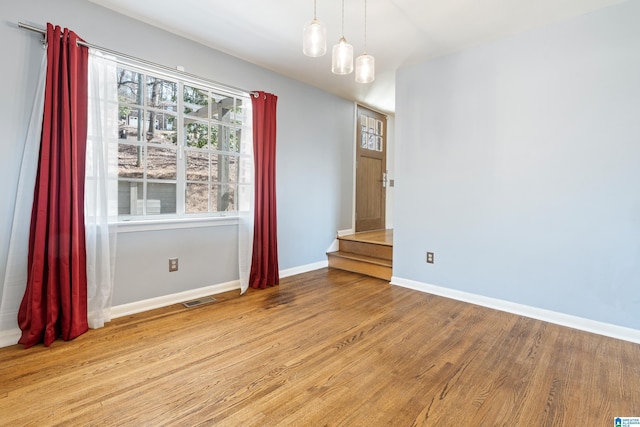 unfurnished dining area featuring wood finished floors, visible vents, and baseboards