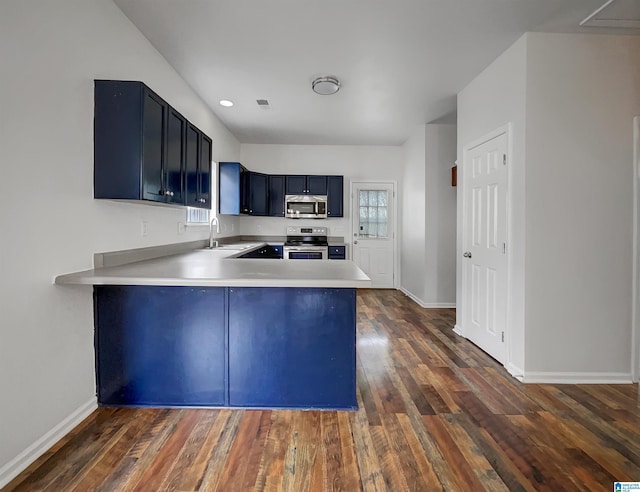 kitchen with a sink, light countertops, dark wood finished floors, and stainless steel appliances