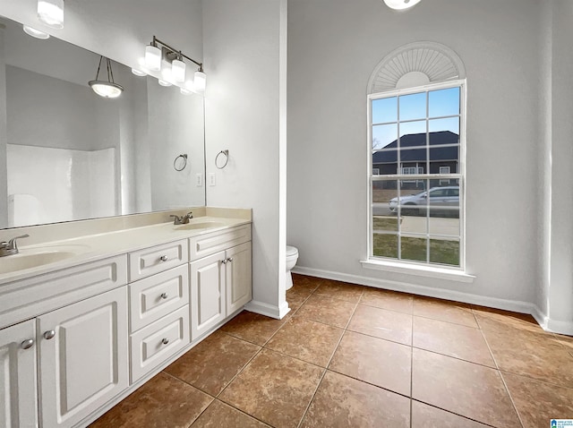 full bathroom with tile patterned floors, plenty of natural light, and a sink