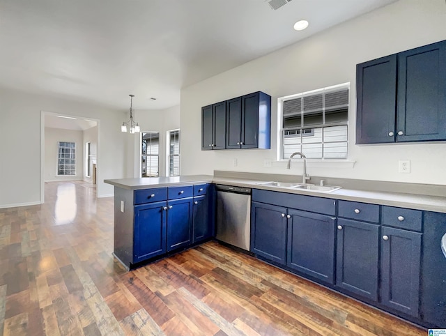 kitchen with a sink, dark wood finished floors, a peninsula, light countertops, and dishwasher