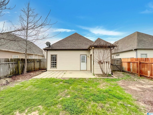 back of house with a yard, a patio, roof with shingles, and a fenced backyard