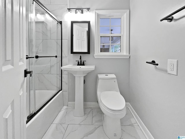 bathroom with baseboards, toilet, marble finish floor, and shower / bath combination with glass door