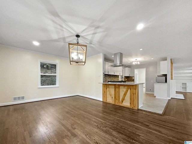 kitchen with open floor plan, visible vents, backsplash, and island range hood