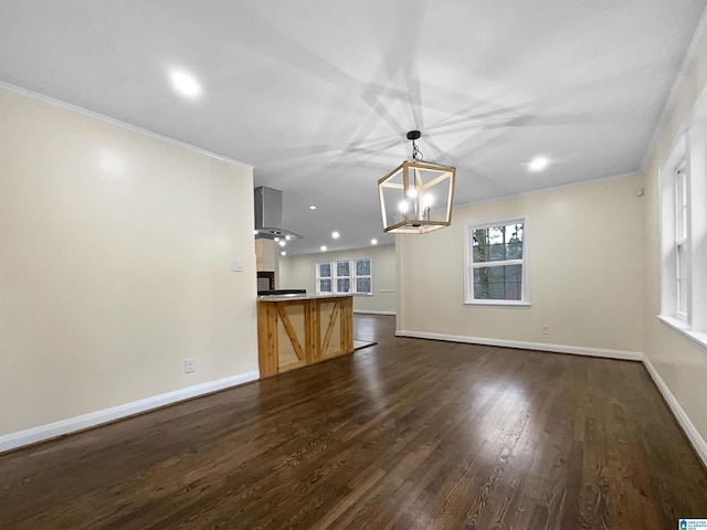 unfurnished living room featuring crown molding, dark wood-type flooring, baseboards, recessed lighting, and an inviting chandelier