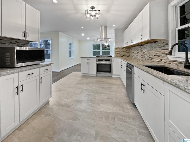 kitchen with a sink, appliances with stainless steel finishes, white cabinets, and island range hood