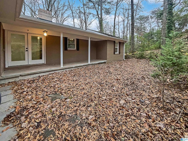 exterior space with french doors and brick siding