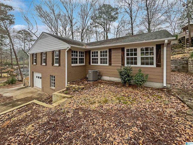 view of side of home featuring a garage, central AC, and driveway