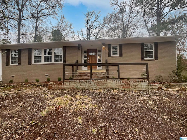 view of front of property featuring brick siding and crawl space