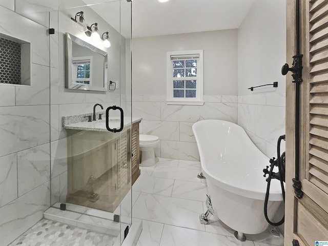 bathroom with marble finish floor, a stall shower, tile walls, a soaking tub, and vanity