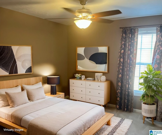 bedroom with a ceiling fan, multiple windows, light colored carpet, and baseboards