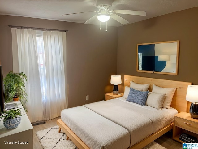 bedroom with visible vents, light wood-style flooring, and a ceiling fan