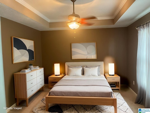 bedroom with light colored carpet, baseboards, a tray ceiling, and ornamental molding