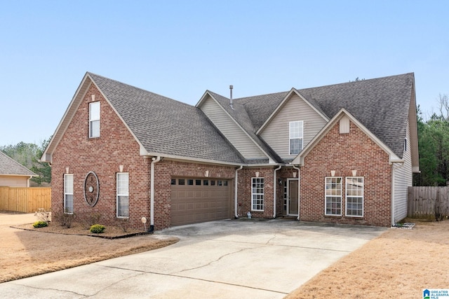 traditional-style house with brick siding, concrete driveway, a shingled roof, and fence