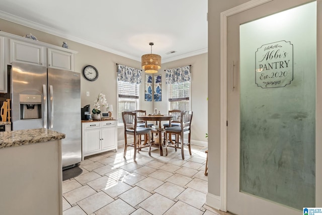 dining space with light tile patterned floors, visible vents, baseboards, and crown molding