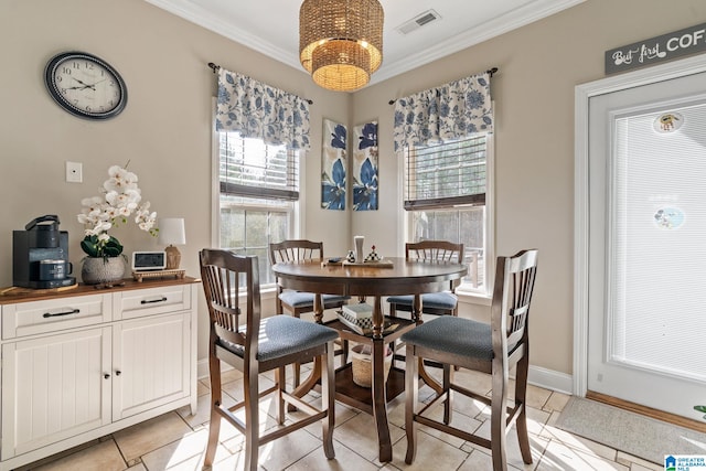 dining space featuring an inviting chandelier, baseboards, visible vents, and ornamental molding