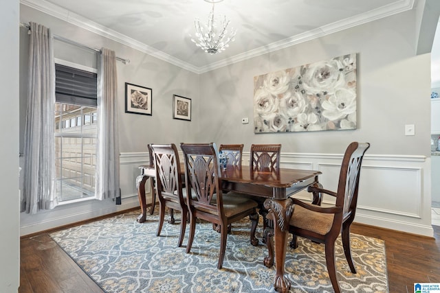 dining space with wainscoting, a notable chandelier, wood finished floors, and crown molding