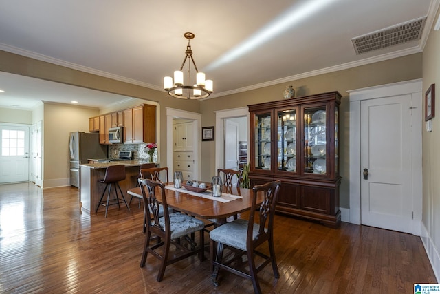 dining area featuring visible vents, an inviting chandelier, dark wood-style floors, and ornamental molding