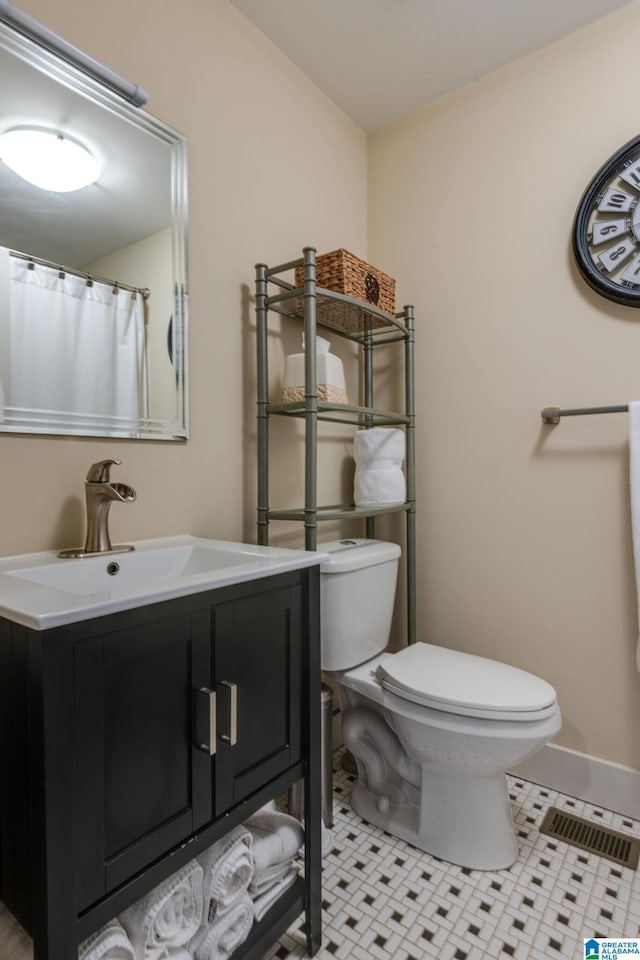 bathroom with visible vents, baseboards, toilet, tile patterned floors, and vanity