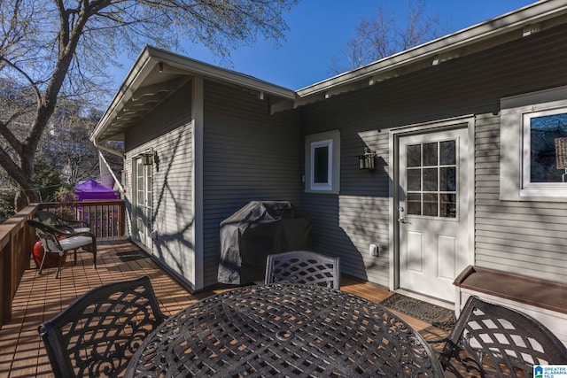 wooden deck featuring area for grilling and outdoor dining area