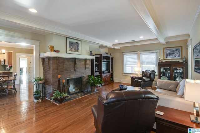 living area with wood finished floors, baseboards, a fireplace, crown molding, and beamed ceiling