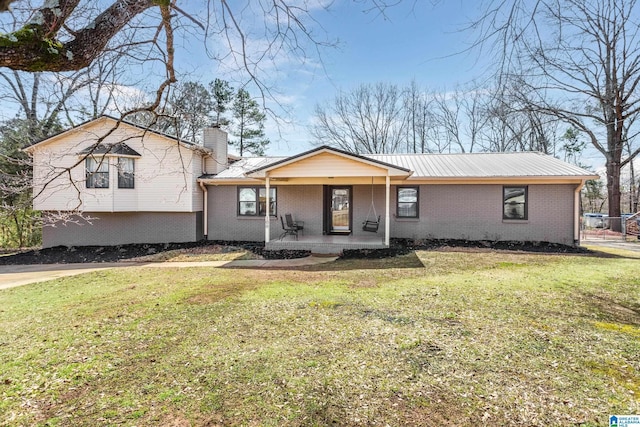 tri-level home featuring a front lawn, a porch, and brick siding