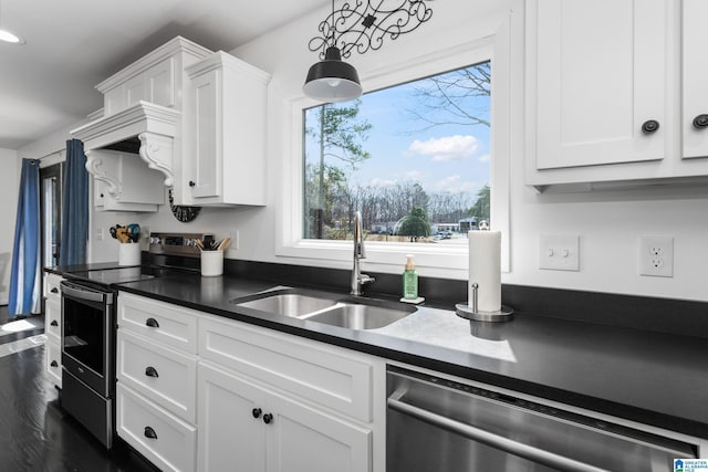 kitchen with a wealth of natural light, a sink, dark countertops, appliances with stainless steel finishes, and white cabinets