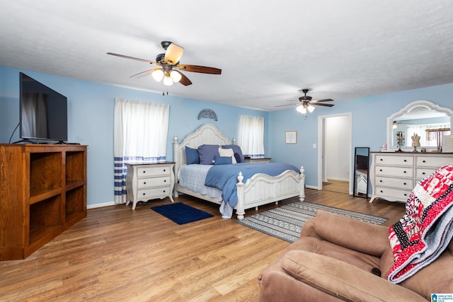 bedroom with a ceiling fan, baseboards, and wood finished floors