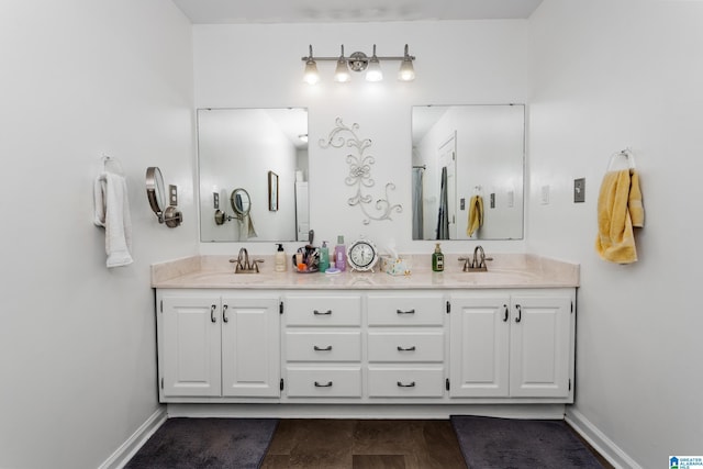 bathroom featuring double vanity, baseboards, and a sink