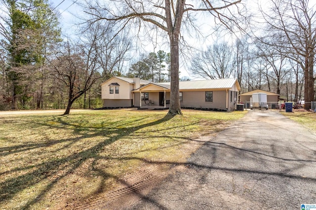 view of front of home featuring central air condition unit, stucco siding, driveway, and a front lawn