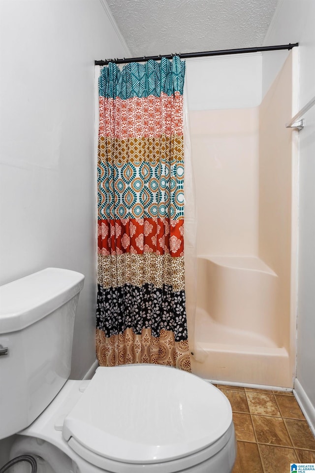 bathroom featuring a shower with curtain, a textured ceiling, and toilet